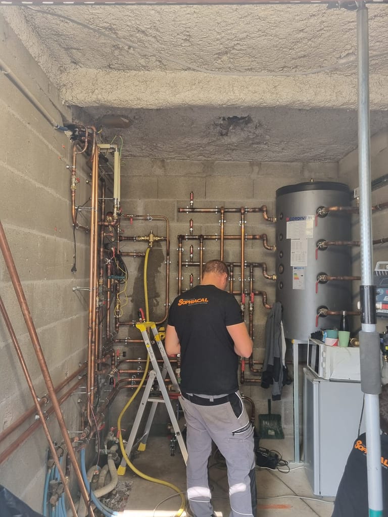 Technicien Sophiacal installant une pompe à chaleur géothermique